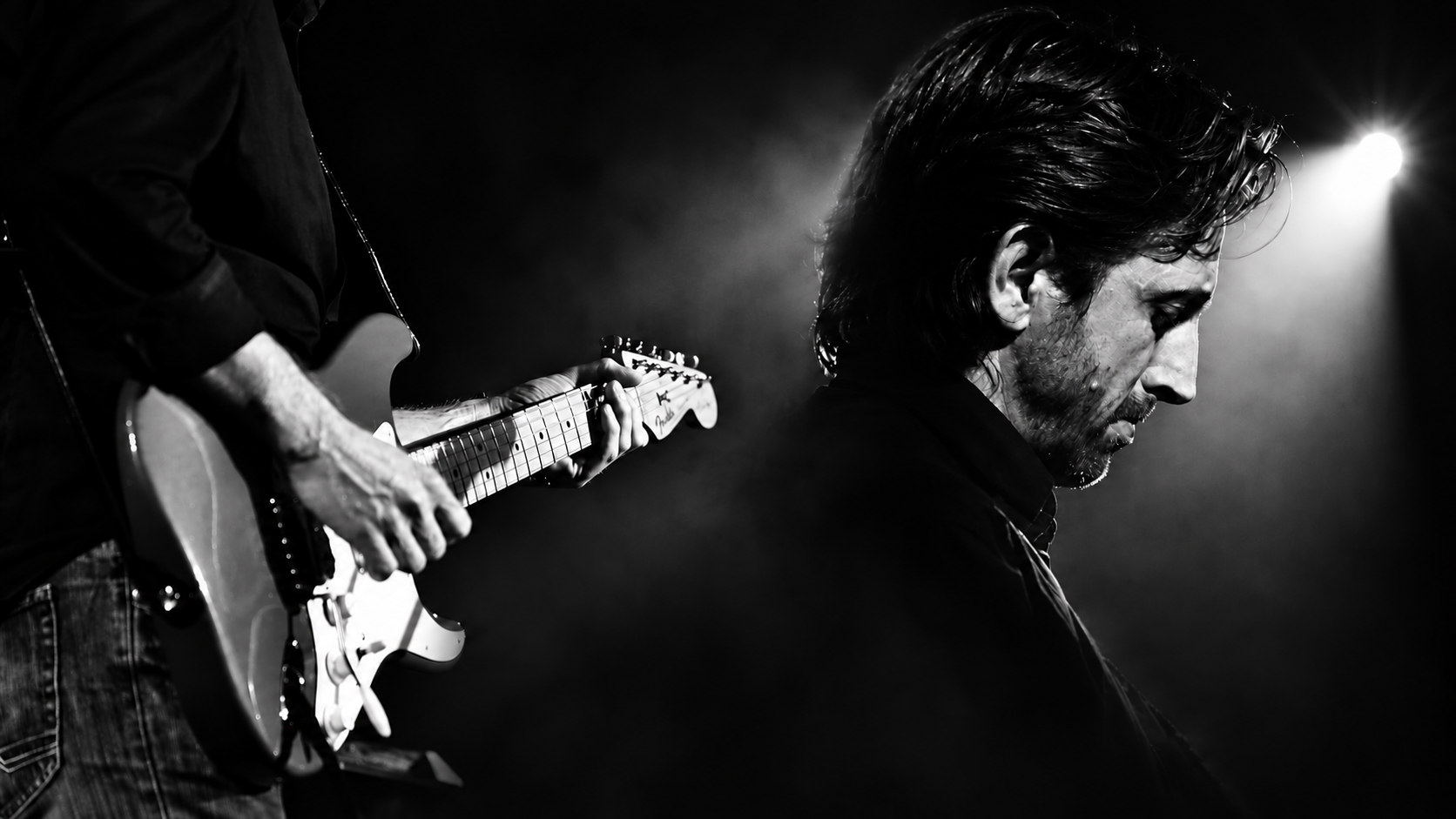 Roberto Apostoli sul palco: fusione in bianco e nero del ritratto e delle mani sulla chitarra elettrica